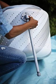 a person is using a sprayer to clean an outdoor hot water heater that's on the ground