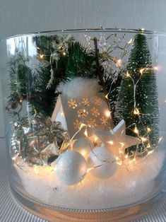 a glass bowl filled with christmas decorations and lights