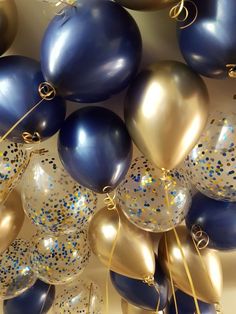 blue and gold balloons are hanging from the ceiling