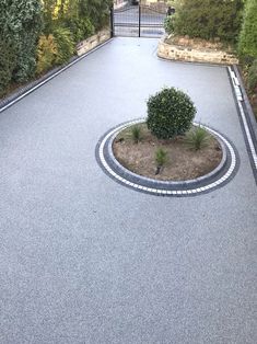 an aerial view of a driveway with a circular planter in the middle