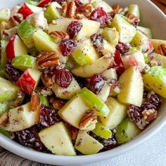 a white bowl filled with fruit and nuts