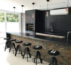 an image of a kitchen setting with bar stools and black counter top in the middle