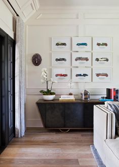 a living room filled with furniture and pictures on the wall next to a white couch