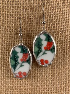 These Antique Chinawear earrings were created from a small Christmas saucer.  Holly leaves and berries are depicted and they measure approximately 3/4" by 1 1/8".  The ear wires are hypoallergenic surgical steel.  Sterling wires are available upon request. Normally I find the unique antique china items that I utilize for jewelry at antique shows and shops. Each design is cut on a porcelain/tile saw, shaped on a grinder, and finished with a silver solder bezel.  We handcraft all of or jewelry in Baton Rouge, La. USA I will ship your Antique Chinawear earrings in a nice gift box. Shipping is free.  Thanks for shopping with me. Nickel-free Round Christmas Earrings, Nickel-free White Earrings For Christmas, Handmade Silver Holiday Earrings, White Sterling Silver Christmas Earrings, Nickel-free Sterling Silver Christmas Earrings, Handmade Sterling Silver Christmas Earrings, Nickel-free Sterling Silver Earrings For Christmas, Holiday Nickel-free Silver Earrings, Nickel-free Silver Earrings For Christmas