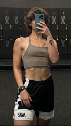 a woman taking a selfie in front of lockers