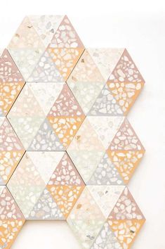 a white wall with an orange and yellow mosaic design on the bottom half of it