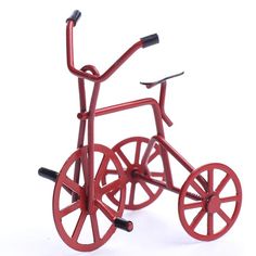 a red bike made out of metal on a white surface with wheels and spokes