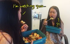 two women sitting at a table with food in their hands and the words i'm watching you