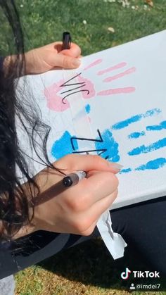 two people sitting on the ground with their feet covered in blue paint