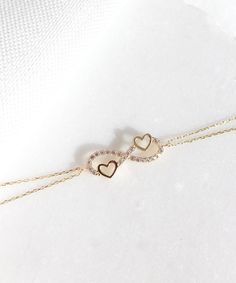 14K Gold Heart and Infinity Symbol Bracelet A symbol of infinite love, this elegant bracelet showcases the symbols of love and eternity entwined with each other. The heart motifs perfectly complements the infinity symbol for a truly romantic look. This unique bracelet is perfect for everyday wear as it is made of solid gold and won't tarnish. It is a wonderful gift for a special person. Features: * This necklace is made of patented 14K solid gold. * It has a 19 cm chain. Packaging: You will get Person Aesthetic, Heart And Infinity, Power Jewelry, Permanent Bracelet, Delicate Gold Bracelet, Eternity Bracelet, Gold Bracelet Simple, Gold Heart Bracelet, Necklace Chain Types