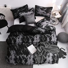 a bed with black and white comforters on it next to a radiator