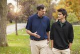 two men standing next to each other in the grass