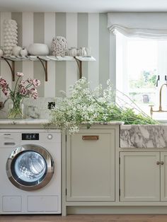 a washer and dryer in a room with striped wall paper on the walls