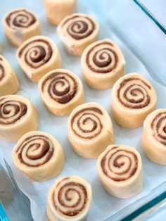 there are many small cinnamon rolls on the baking sheet, ready to be baked in the oven