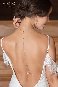 the back of a woman's wedding dress with a diamond necklace