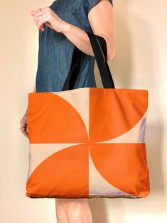 "Meet my colorful mid century geometric Pinwheel tote in pink and orange This large, lined retro, geometric handbag in cotton canvas is great for yoga, pool, groceries, and overnights Check out the handy wallet sized pockets on the inside, the bag is fully lined with a snap closure. Extra room to fit all the things. Designed in my Berkeley studio, this colorful bag is a great girlfriend or hostess gift, mostly I'm seeing folks nab them for theirselves (encouraged!) Made to order. The original ar Orange Canvas Tote Bag For Everyday Use, Everyday Retro Rectangular Beach Bag, Retro Orange Shoulder Bag For Everyday, Retro Tote Beach Bag For Everyday Use, Retro Everyday Rectangular Beach Bag, Large Capacity Orange Beach Bag For Everyday Use, Everyday Use Orange Canvas Tote Bag, Orange Canvas Shoulder Bag For Shopping, Orange Rectangular Canvas Bag For Summer