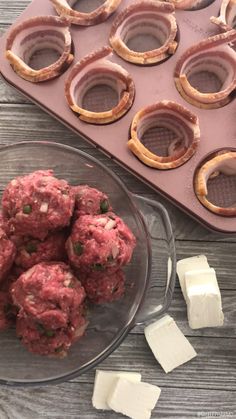 mini meatballs in a muffin tin with pretzels next to them on a wooden table