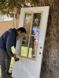 a man is painting the side of a white door