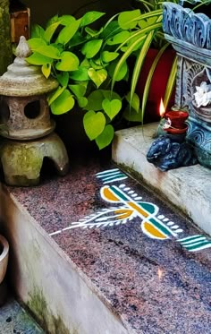 a close up of a sign on the ground near some potted plants and candles