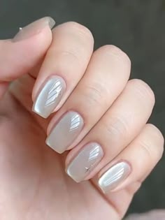 a woman's hand with white and silver nail polish