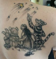 the back of a woman's shoulder with an image of winnie the pooh and tigger on it