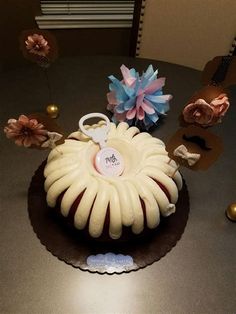 a cake decorated with flowers and a key on the top is sitting on a table