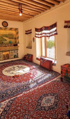 a large rug is in the middle of a room with two windows and a painting on the wall