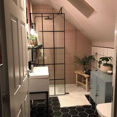 a bathroom with a toilet, sink and shower in it's attic dormer