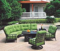 an outdoor patio furniture set with green cushions