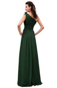 a woman in a long green dress with her back to the camera, looking down