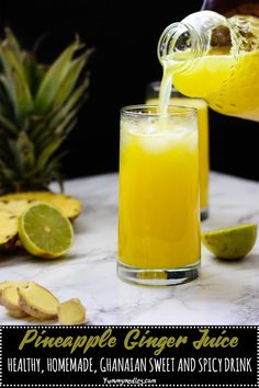 pineapple juice being poured into a glass next to sliced pineapples on a marble table