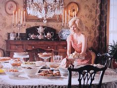 a woman sitting at a table in front of a bunch of plates with food on it