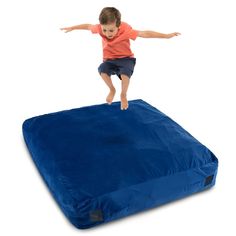 a young boy jumping on an inflatable mattress