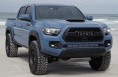 a blue toyota truck parked on the beach