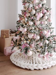 a white christmas tree with pink and gold ornaments