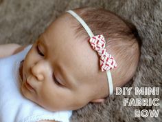 a baby wearing a red and white headband laying on top of a carpeted floor