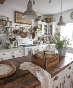 a kitchen with lots of pots and pans hanging from the ceiling, on top of a wooden counter