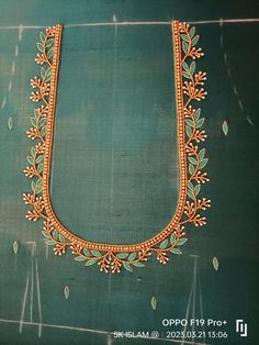 an embroidery work on the back of a green cloth with gold trimmings and beads