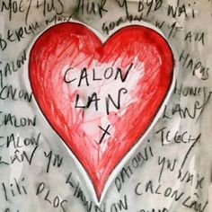 a red heart with the words calon lanf written on it in many languages