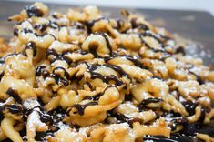 a pile of food that is on top of a wooden cutting board with chocolate drizzled over it