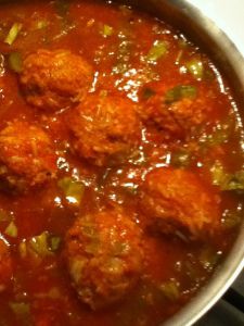 some meatballs are cooking in a pot on the stove top and is ready to be eaten