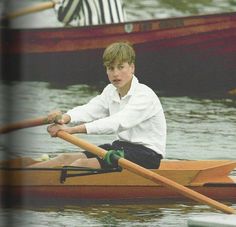 a boy in a white shirt is rowing a boat