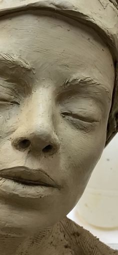 a clay sculpture of a woman's face with her eyes closed