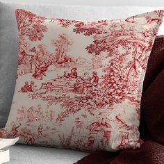 a red and white pillow sitting on top of a couch