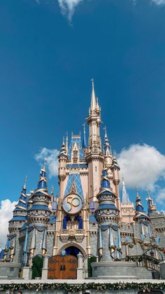 a castle with a clock on it's side in front of a blue sky