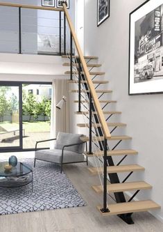 a living room with a stair case next to a glass table