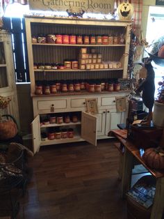 a store filled with lots of jars and pumpkins on display in front of the window