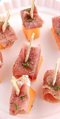 small appetizers are arranged on a plate with toothpicks