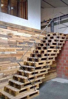 some stairs made out of wooden pallets next to a brick wall