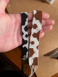 two beaded bracelets in the shape of giraffes on a table